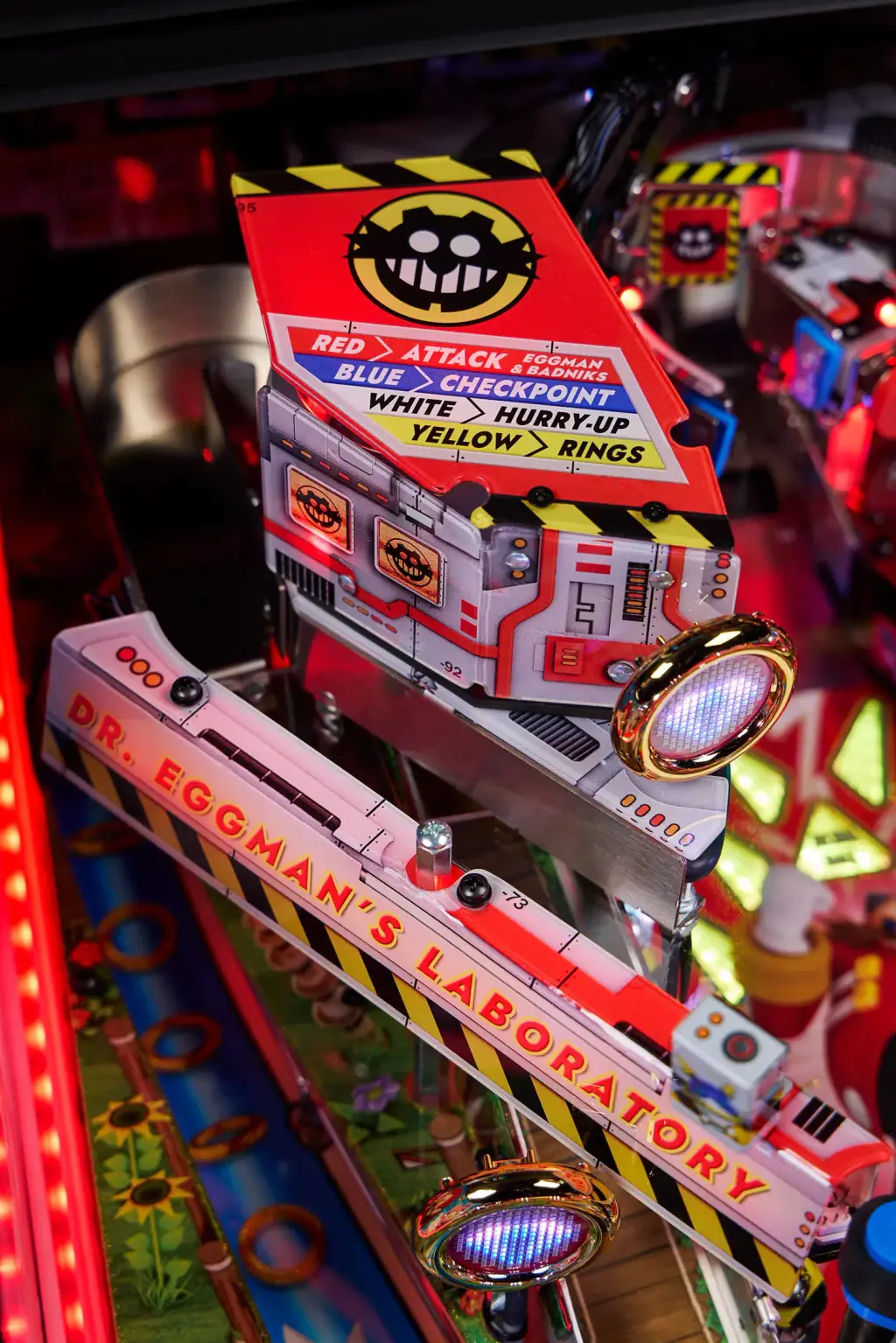 Le décor en relief du laboratoire, sur le plateau supérieur du flipper Sonic : une boîte rouge et blanche, des bandes jaunes et noires, une rampe éclairée.