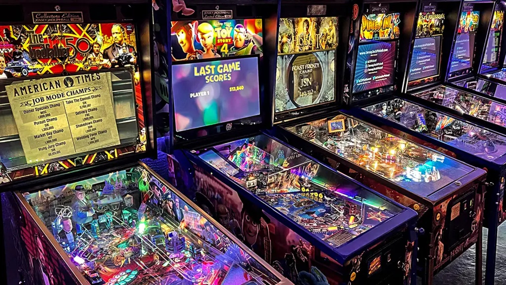 Une rangée de flippers Jersey Jack Pinball allumés côte à côte dans l’usine.