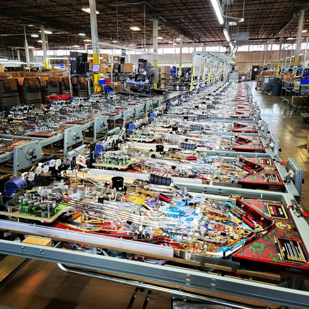 La chaîne d’assemblage de l’usine Jersey Jack Pinball : des dizaines de plateaux de flipper en cours de montage, alignés jusqu’au fond de la halle.