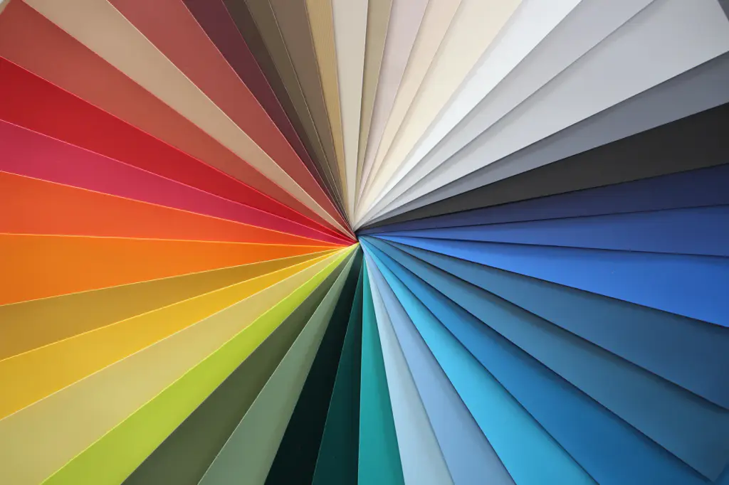 Photograph by the manufacturer Serge Ferrari: a fabric swatch book fanned out, from reds and oranges to blues, by way of greys and whites.