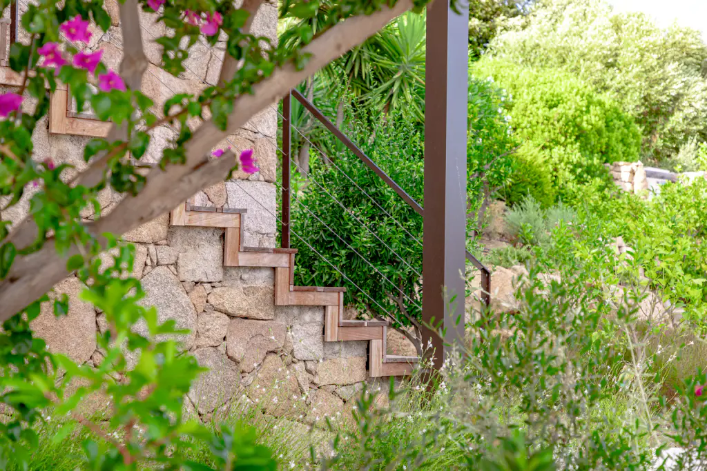 Blurred bougainvillea in the foreground, stone staircase, pergola post.