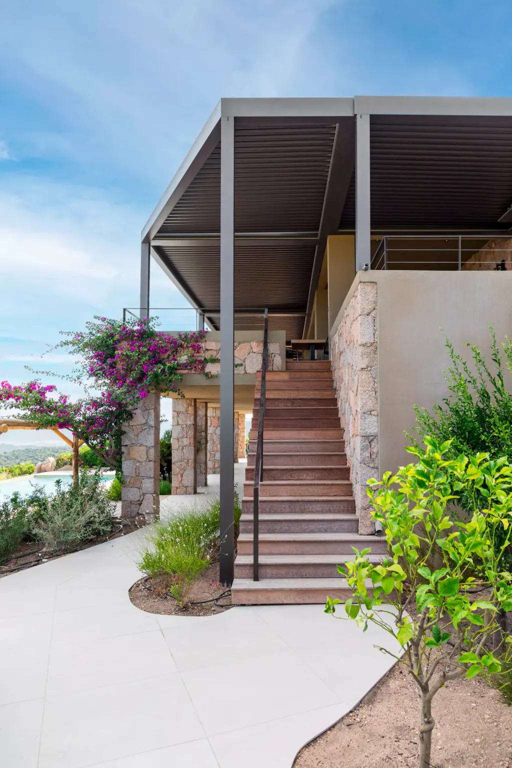 Anthracite pergola on an upper level above stone steps, bougainvillea, light path.