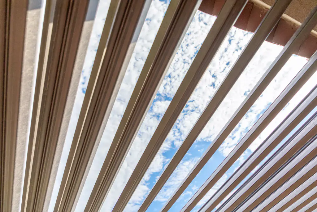 Open louvres seen from below on the diagonal, mackerel sky between the louvres.