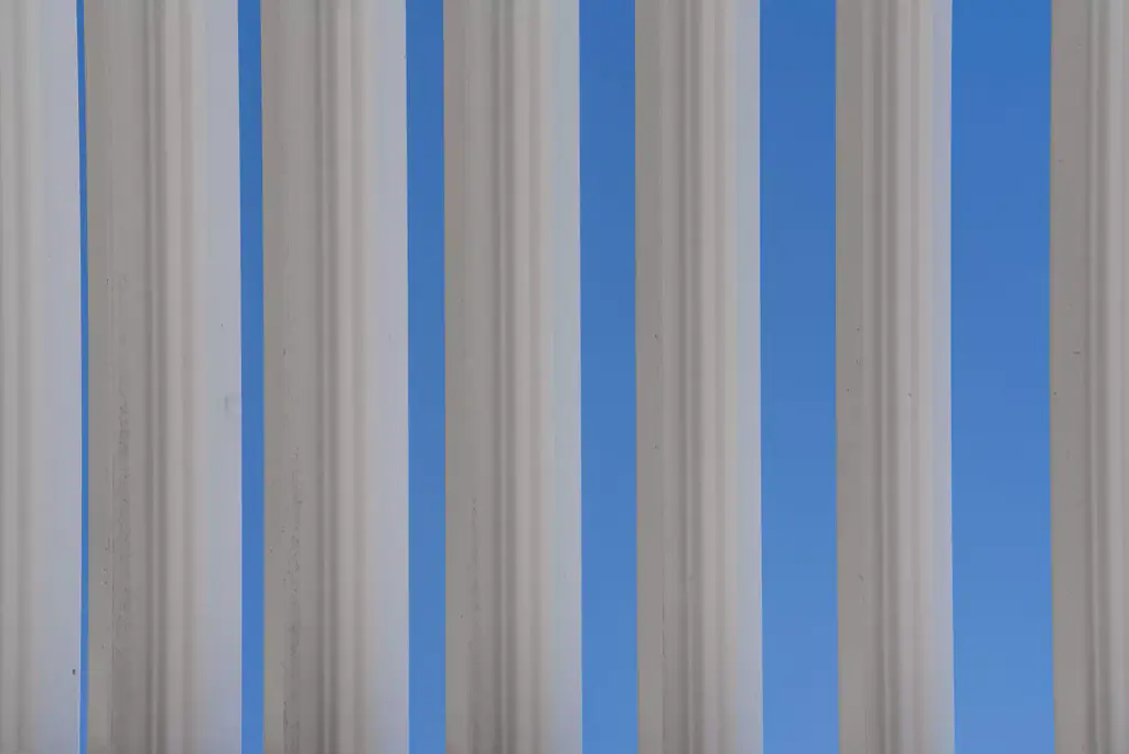Open white louvres and blue sky, in vertical bands.