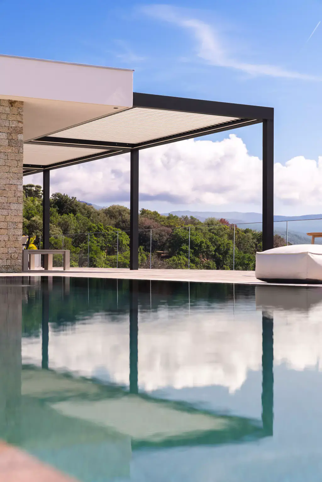 La pergola reflétée en miroir dans la piscine, sous les nuages.