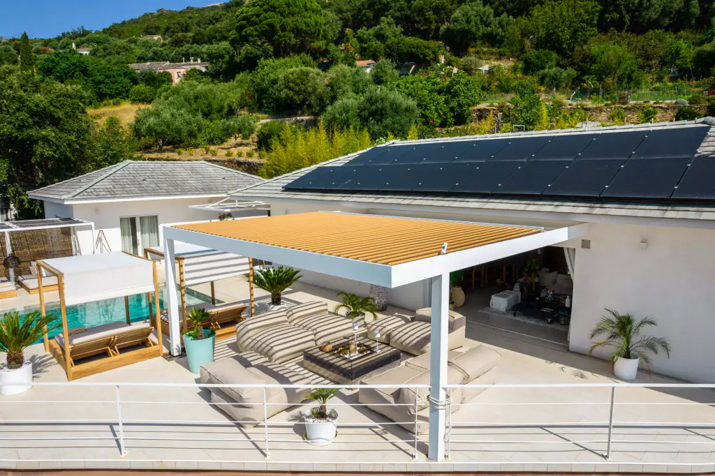 Vue drone plus large, lames fermées : lit à baldaquin, piscine, garde-corps.