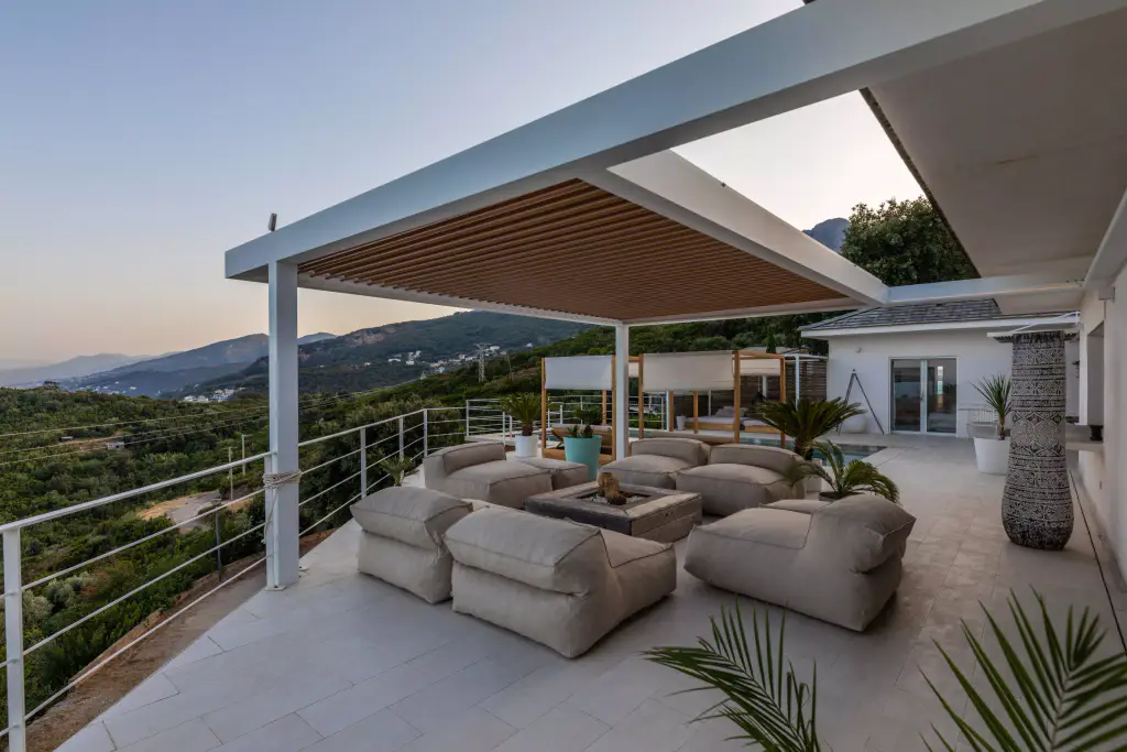 Pergola vue de côté au crépuscule, villa et maquis.
