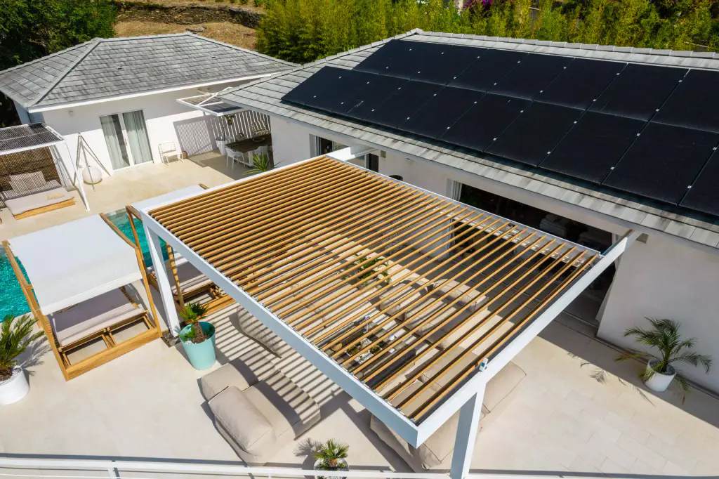 Vue drone sous un autre angle : lames ouvertes, lit à baldaquin, piscine.