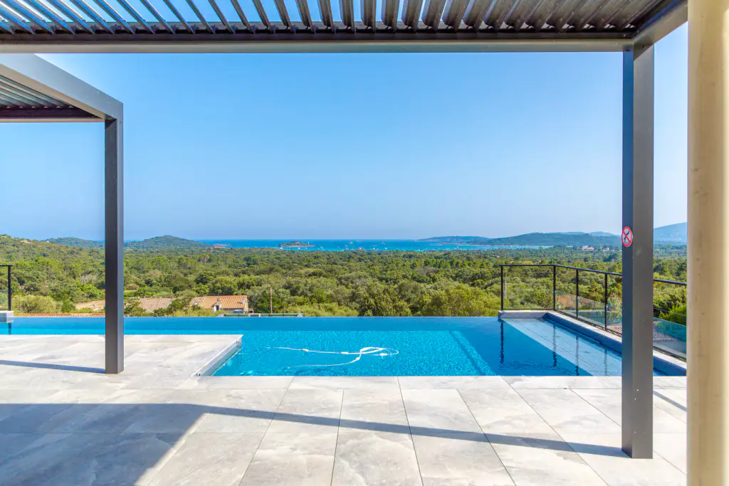 Under the pergola (open louvres at the top of the image), which frames the infinity pool, the maquis and the sea.