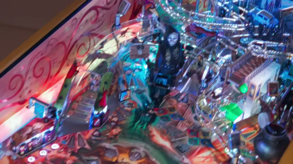 Le plateau d’un flipper Jersey Jack Pinball filmé de près : rampes métalliques, cibles et inserts lumineux dont les couleurs changent.
