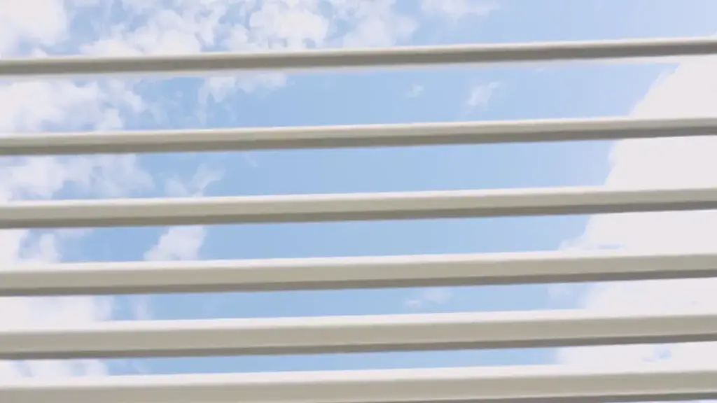 Les lames claires de la pergola pivotent et s’ouvrent sur le ciel.