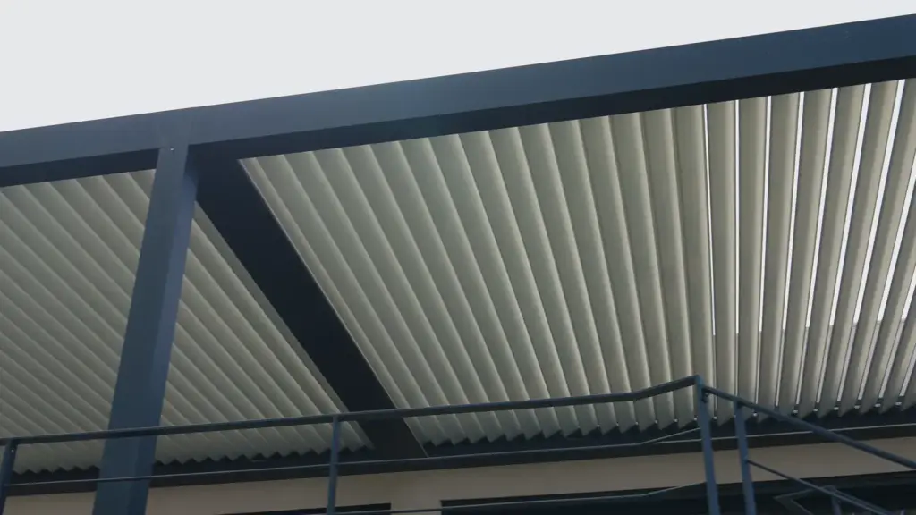 Casa Monte: the camera moves under the pergola, along a post and the balustrade, then the fully open louvres seen from below, sky and foliage between them.