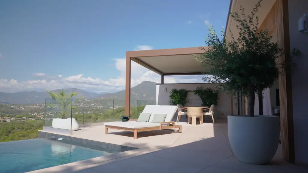 La piscine à débordement, le bain de soleil, la pergola et les montagnes, puis les lames fermées contre le ciel bleu.