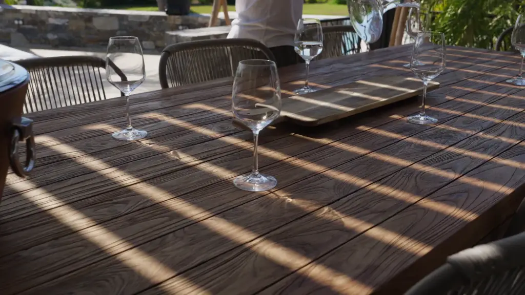 Les ombres des lames sur le parquet de la terrasse, puis sur la table de bois dressée.