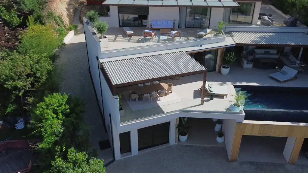 Trois vues de drone : la villa en terrasses et sa piscine, la pergola à la verticale, la villa dans la colline boisée.