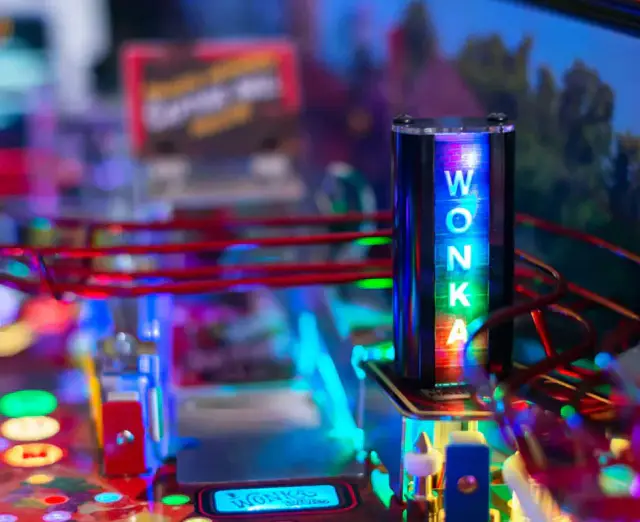 Gros plan du plateau du flipper Willy Wonka : une colonne lumineuse marquée « Wonka » au milieu des rampes et des lumières.