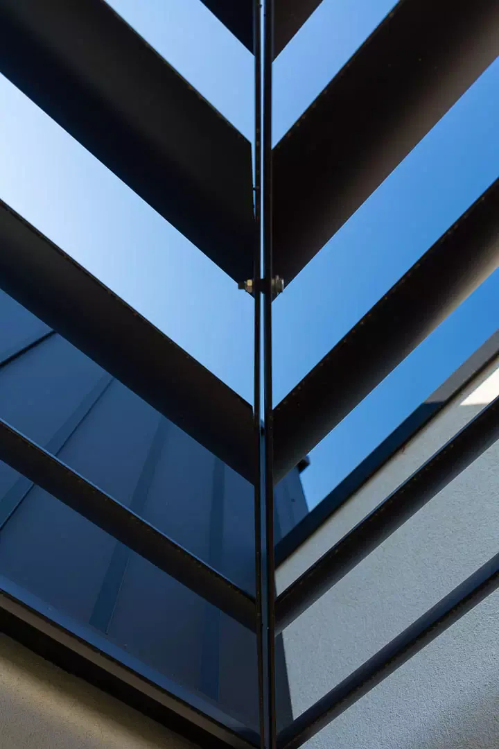 Chevron detail of the brise-soleil louvres against the blue sky.